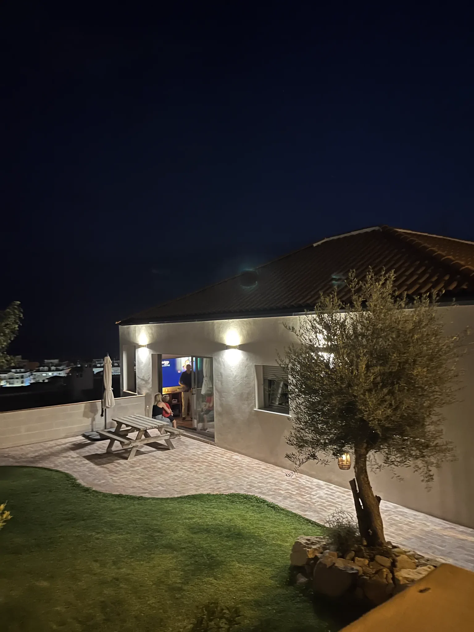 Exterior de noche con olivo y jardín de la casa bioclimática de La Cala del Moral